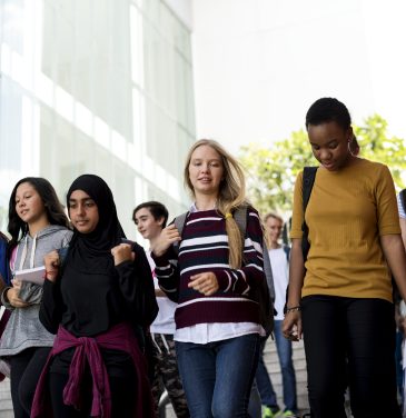 Diverse group of students walking in school